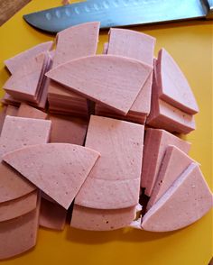 sliced up pieces of food sitting on top of a yellow cutting board