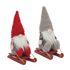 two small gnomes on sleds with red and grey hats