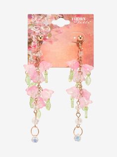 the pink flower earrings are attached to gold chains with crystal beads and danglings on them