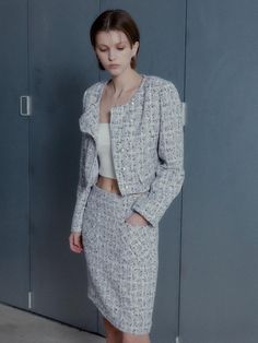 This product is a modern rendition of a classic tweed mini skirt, featuring an asymmetrical cut that lends a contemporary edge to the timeless fabric. The skirt is meticulously tailored to sit comfortably at the waist, cascading into an off-kilter hemline that makes a bold fashion statement. Paired with a coordinating cropped jacket, this ensemble is both polished and trendsetting. - The mini skirt is cut with an asymmetrical hemline, offering a fresh take on traditional tweed.- It is exper Classic Tweed Skirt For Spring, Spring Classic Tweed Skirt, Classic Spring Tweed Skirt, Elegant Mini Tweed Dress, Asymmetrical Cut, Tweed Mini Skirt, Cropped Jacket, Crop Jacket, Bold Fashion