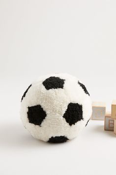 a black and white soccer ball next to wooden blocks