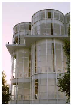 people are standing on the balconies of a large white building with many windows