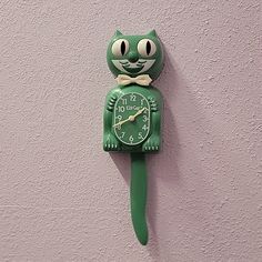 a green clock with a cat face on it