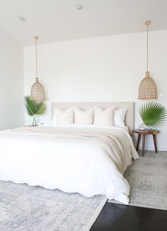 a large bed sitting in a bedroom next to two planters on either side of the bed