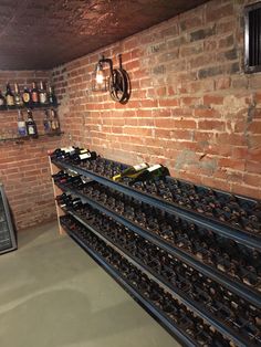 a wine cellar with several rows of bottles on the shelves