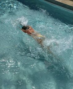 a man is swimming in the pool with his head above the water's surface