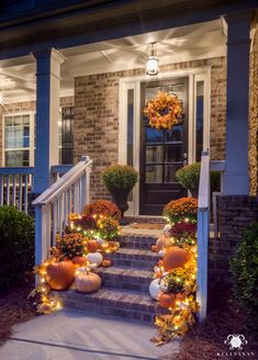 front porch decorated for halloween with pumpkins and lights