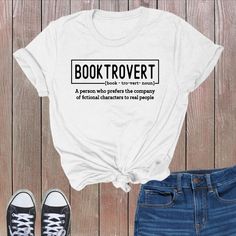 a white t - shirt with the words book trovet printed on it next to jeans and sneakers