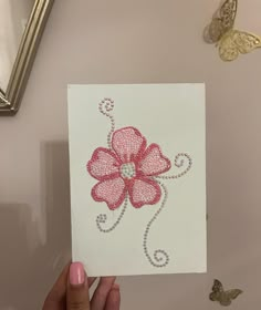 a hand holding up a card with a flower on it