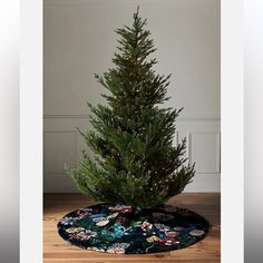 a small christmas tree in a room with wood flooring