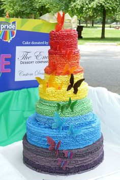 there is a multi colored cake made out of crocheted material and butterflies on it