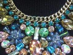 "Massive glittering crystal bib collar necklace The incredible huge scale bib style necklace is embellished with a collection of prong set glass crystals in a myriad of colors & shapes The top section of the necklace is designed with a rigid gilt metal chain framed with a wreath of emerald green color prong set crystals The lower section of the bib collar necklace is adorned with brilliant shimmering prong set crystals in a spectrum of colors that range from pink, pale & emerald green, a Rhinestone Jeweled Choker Necklace, Costume Jewelry Bib Necklace With Jewels, Party Costume Jewelry Bib Necklace With Rhinestones, Jeweled Crystal Costume Jewelry Necklace, Multicolor Crystal Necklaces For Parties, Rhinestone Jewel Choker Necklace, Party Jeweled Crystal Bib Necklaces, Glamorous Bib Necklace With Rhinestones, Unique Multicolor Bib Necklaces With Colorful Beads