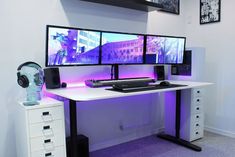 two computer monitors sitting on top of a white desk