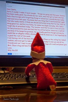 an elf sitting in front of a laptop computer with a message on it's screen