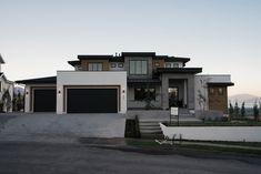 a large house with two garages and steps leading up to the front door,