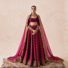 a woman in a red and gold lehenga