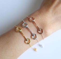 three different bracelets on someone's arm with gold, silver and diamond links