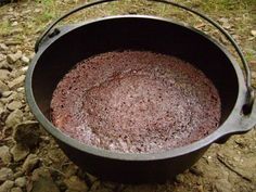 a pot that is sitting on the ground with dirt in it and rocks around it