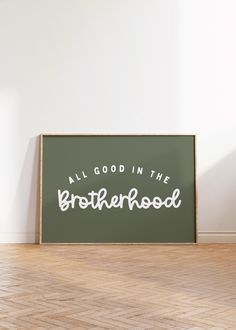 an all good in the brotherhood sign sitting on top of a hard wood floor