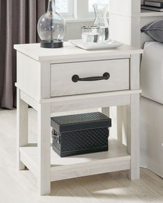 a white night stand with two drawers and a basket on the bottom shelf next to it