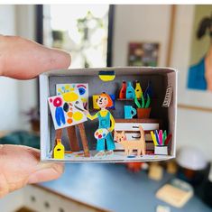 a person holding up a small box with magnets on it's front and side