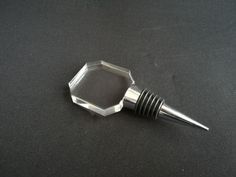 a metal object with a screw in the middle on a black surface, it appears to be part of something that looks like hexagonal