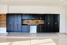 an empty room with black cabinets and drawers