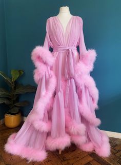 Beautiful chiffon dressing gown in Baby Pink.  Trimmed along the hem and the sleeve edges with fluffy marabou feathers.  Ties around the waist with a matching chiffon belt.  One size fits all due to the design and fullness of the robe.  Perfect for family gatherings, walking the dogs as well as taking out the rubbish.  Please expect some feathers to shed - no one can look this fabulous without losing a few feathers. Fliffy Robe, Luxury Feminine Pink Robe, Silk Robe With Fur Trim, Pink Ostrich Feather Robe, Sheer Fur Trimmed Robe, 70s Feather Robe, Fur Edged Robe, Champagne Dressing Gown Fluffy Robe, Luxury Pink Women's Robe