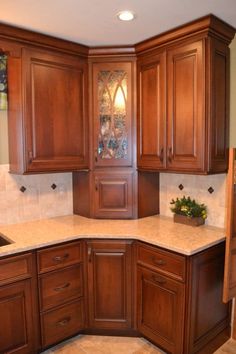 a kitchen with wooden cabinets and marble counter tops