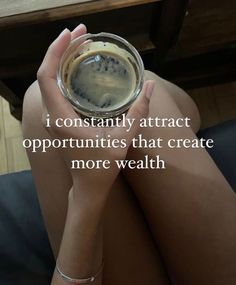 a woman holding a glass with liquid in it and the words i constantly attract opportunity that create more wealth