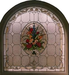 a stained glass window with flowers in the center and an ornate frame around it,