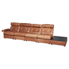 a brown leather couch sitting on top of a wooden table