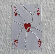 a broken playing card with hearts and arrows on the back is cut out to look like a spider