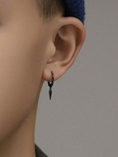 a close up of a person's ear wearing black earrings with spikes on them