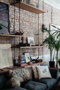 a living room filled with lots of furniture and bookshelves next to a brick wall