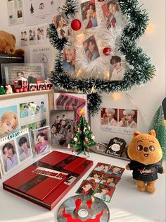 there is a christmas tree with many pictures on it and a teddy bear next to it