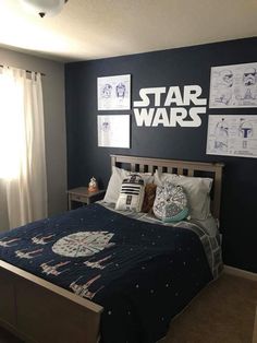 a star wars themed bedroom with blue walls and pictures on the wall above the bed