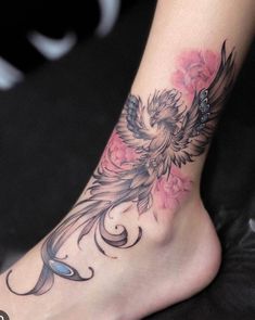 a woman's foot with a bird and flowers tattoo design on the bottom of it