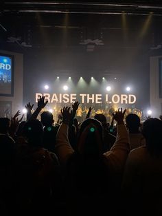 people at a concert raising their hands in the air