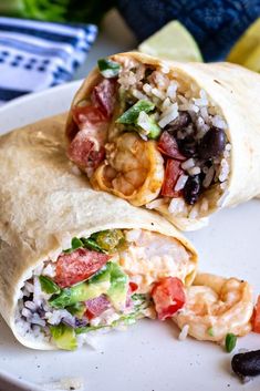 a burrito cut in half on a white plate