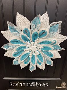 a blue and white flower is hanging on the front door