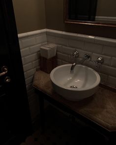 a white sink sitting under a bathroom mirror