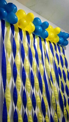 blue and yellow streamers are hanging on the wall