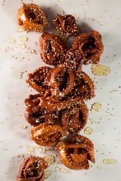 there are some pretzels on the table with sesame seeds scattered around them and drizzled with brown sugar