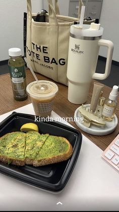 there is a tray with some food on it next to a coffee cup and bag