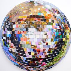 a large mirror ball with many different colored tiles on it's sides and bottom