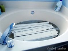 a bathtub filled with lots of toilet paper and toothbrushes next to a sink