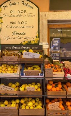 the fruit stand has many different types of fruits in boxes on it's shelves