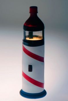 a red and white lighthouse shaped bottle with a light on it's side, sitting on a table