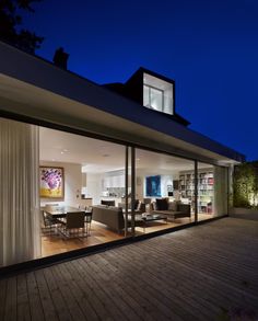 an open living room and dining area are lit up at night